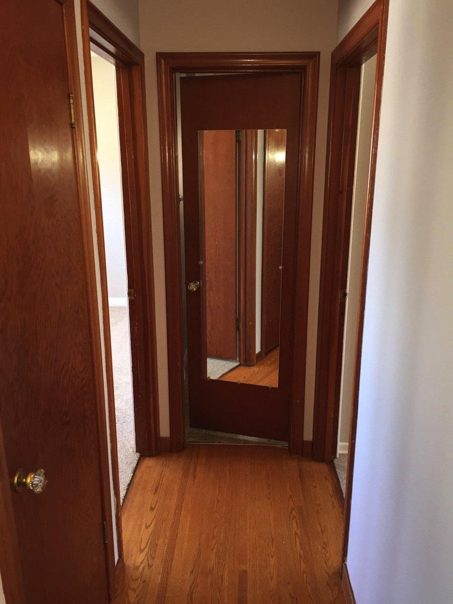 Short hall to bathroom, bedrooms are on either side on the right, the glass doorknob to the left is on the broom closet door.